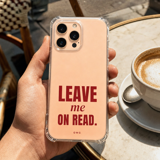 Clear iPhone case printed “Leave me on read.” in deep red, held beside a cappuccino